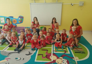Zdjęcie dzieci i opiekunek ubranych na czerwono.