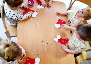 Dzieci z grupy Biedroneczki pracujące przy stoliku podczas zajęć plastycznych