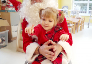 Zdjęcie Mai na kolanach u Świętego Mikołaja.