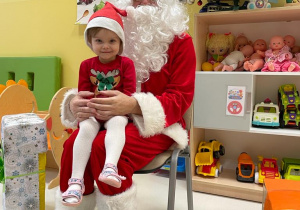 Zdjęcie Klaudii siedzącej na kolanach u Świętego Mikołaja.