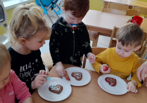 Aleksander, Olek i Lila podczas ozdabiania kolorowymi pisakami swoich ciasteczek.