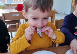 Aleksander smakujący swoje słodkie ciasteczko.