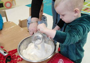 Zdjęcie Henryka wsypującego cukier do miski z mąką.