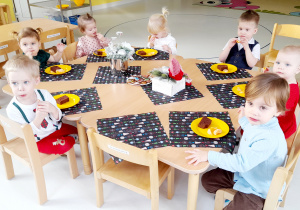 Zdjęcie dzieci siedzących przy świątecznym stole.