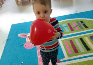 Zdjęcie Bartoszka z czerwonym balonikiem w kształcie serca.