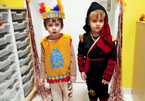 Dwaj chłopcy pozują do zdjęcia w swoich kostiumach.