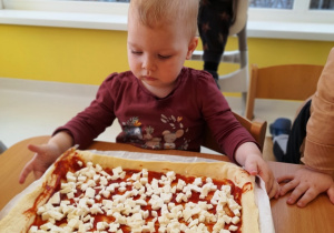 Zoja przygląda się pizzy przygotowanej przez wszystkie dzieci.