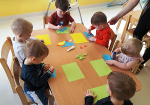 Zdjęcie dzieci z grupy Biedroneczki siedzących przy stoliku podczas zajęć.