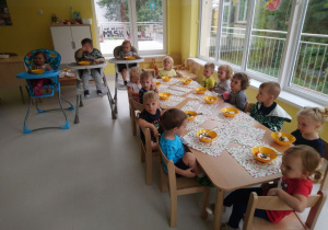 Zdjęcie dzieci siedzących przy stole z deserami.