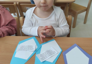 Zdjęcie Lilianny podczas przyklejania małych białych karteczek z życzeniami.