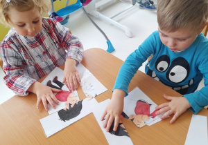 Lila i Dorian układają obrazek z chłopcem.