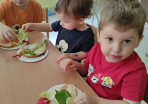 Bartosz, Stanisław i Oliwier zajadają swoje kanapki.