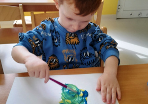 Aleksander podczas zajęć z farbami.
