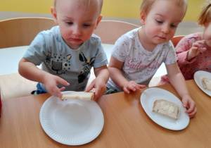 Zdjęcie Adasia i Anielki z chlebkiem posmarowanym masłem czekających na robienie kanapek.