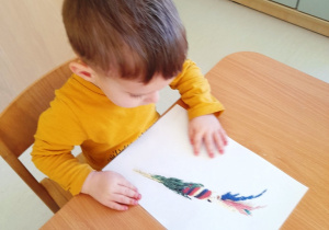 Aleksander ogląda ilustrację z palemką wielkanocną.