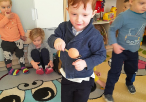 Aleksander niesie ugotowane jajko na łyżce.