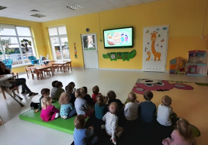 Dzieci oglądają filmik edukacyjny w celu utrwalenia tradycji wielkanocnych.