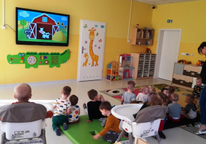 Zdjęcie dzieci oglądających podczas zajęć filmik edukacyjny o wiejskich zwierzętach.