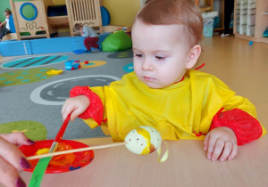 Zdjęcie Szymona nabierającego żółtą farbę swoim pędzelkiem.