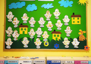 Zdjęcie tablicy grupy Pszczółki z wykonanymi przez dzieci plastelinowymi kurczaczkami.