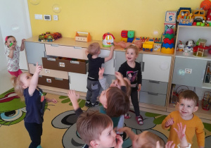 Dzieci z grupy Biedroneczki łapią bańki mydlane.
