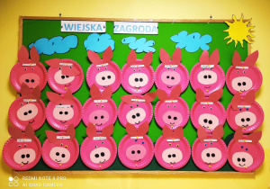 Zdjęcie tablicy grupy Pszczółki z wykonanymi przez dzieci pracami plastycznymi pt. ,,Różowa świnka''.