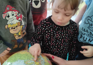 Alicja wskazuje na globusie zarys Polski.