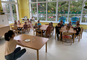 Zdjęcie opiekunki i dzieci przed zajęciami badawczymi.