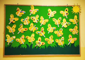 Zdjęcie tablicy grupy Pszczółki z wykonanymi przez dzieci pracami plastycznymi pt. ,,Wiosenne pomponikowe motylki''.