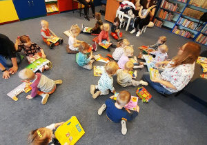 Zdjęcie dzieci oglądających kolorowe książki.