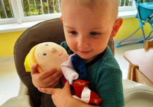Adam przytula pacynkową lalkę.