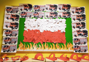 Zdjęcie tablicy grupy Pszczółki z wykonanymi przez dzieci pracami pt. ,,Serduszkowa flaga Polski'' , ,,Strażackie puzzle''.