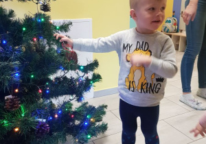 Marcel ozdabia świąteczne drzewko własnoręcznie zrobionym reniferem.