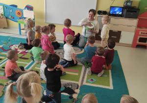 Zdjecie dzieci z grupy Pszczółki siedzących na dywanie podczas zajęć o instrumentach muzycznych.