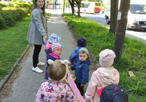 Zdjęcie opiekunki i dzieci podczas spacerku wokół żłobka.
