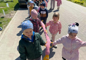Zdjęcie dzieci trzymających węża spacerowego podczas wędrówki.