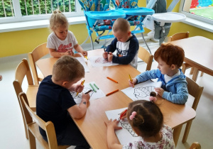 Dzieci z grupy Biedroneczki podczas malowania kredkami.