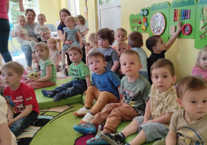 Zdjęcie dzieci z grupy Pszczółki siedzących na materacu podczas koncertu pt. ,,AFRYKA DZIKA''.