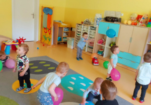 Fotografia dzieci podczas zabawy z kolorowymi balonikami.
