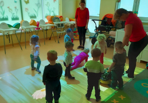 Dzieci i opiekunki z grupy Motylki bawią się na magicznym dywanie.