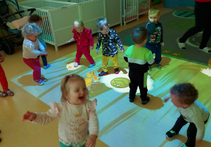 Zdjęcie dzieci bawiące się na polance wyświetlanej za pomocą rzutnika.