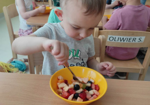 Zdjęcie Nikodema jedzącego kolorową sałatkę owocową.