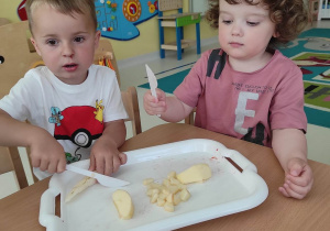 Zdjęcie Bartosza i Brunona podczas krojenia gruszek.
