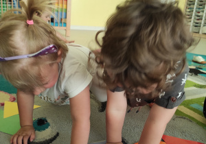 Alicja i Bruno wspólnie kładą na dywanie fioletowy kwadrat.