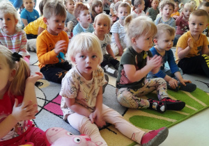 Dzieci z grupy Biedroneczki klaszczące do granej na instrumencie melodii.
