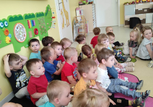 Zdjęcie dzieci z grupy Pszczółki siedzących na materacu na koncercie Akademii Feliksa pt. ,,JAKA TO MELODIA''.