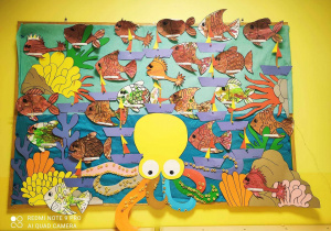 Zdjęcie tablicy grupy Pszczółki przedstawiającej morski pejzaż, na którym umieszczone zostały wykonane prze dzieci morskie łódki.