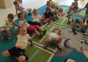 Zdjęcie dzieci ćwiczących na dywanie.