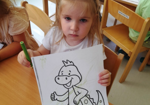 Maja pozuje do zdjęcia ze swoim rysunkiem.