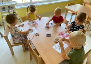 Dzieci z grupy Żabki siedzące przy stoliku podczas zajęć.